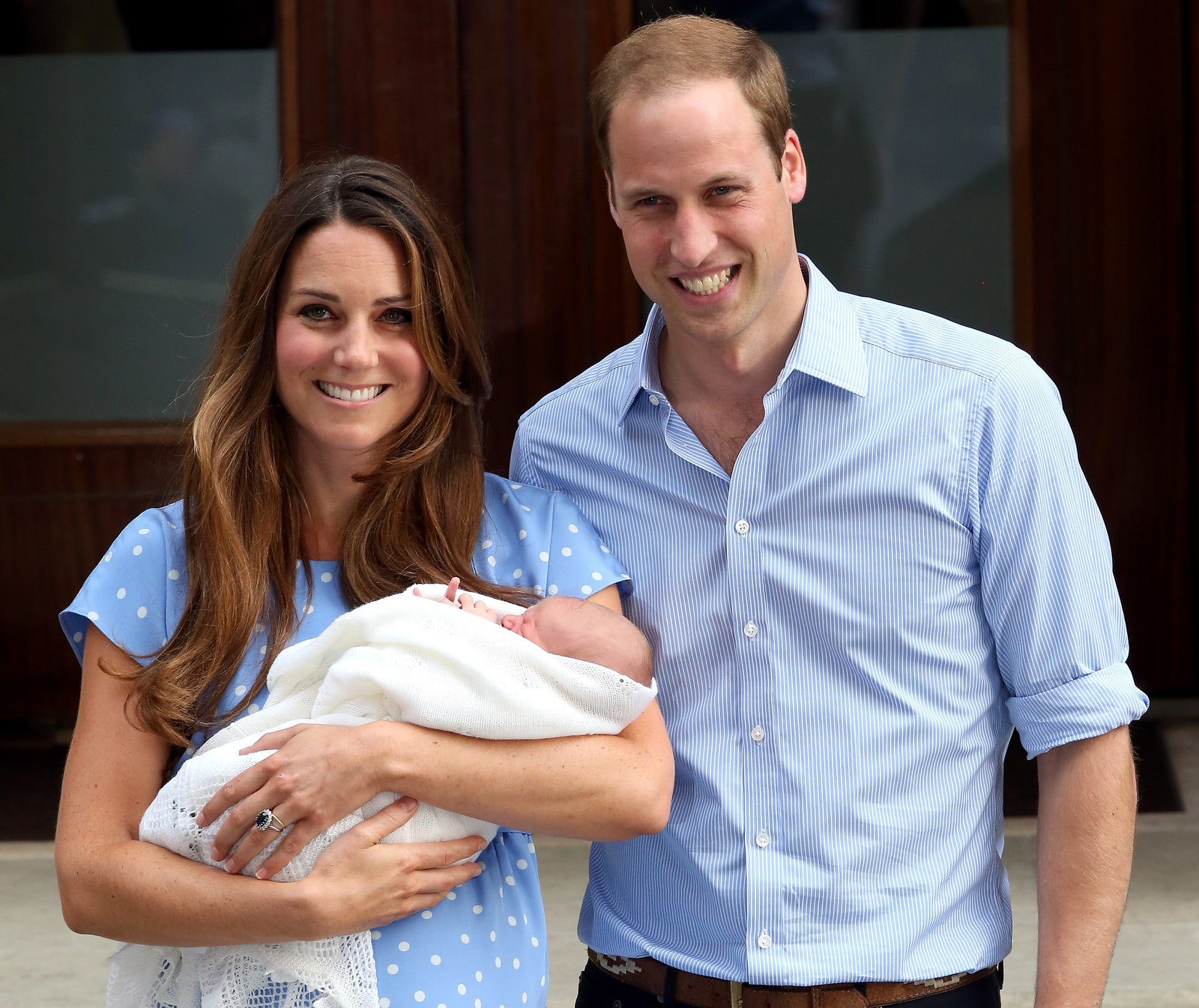 De hertog en hertogin van Cambridge poseren met hun eerste kind prins George buiten het ziekenhuis op 23 juli 2013
