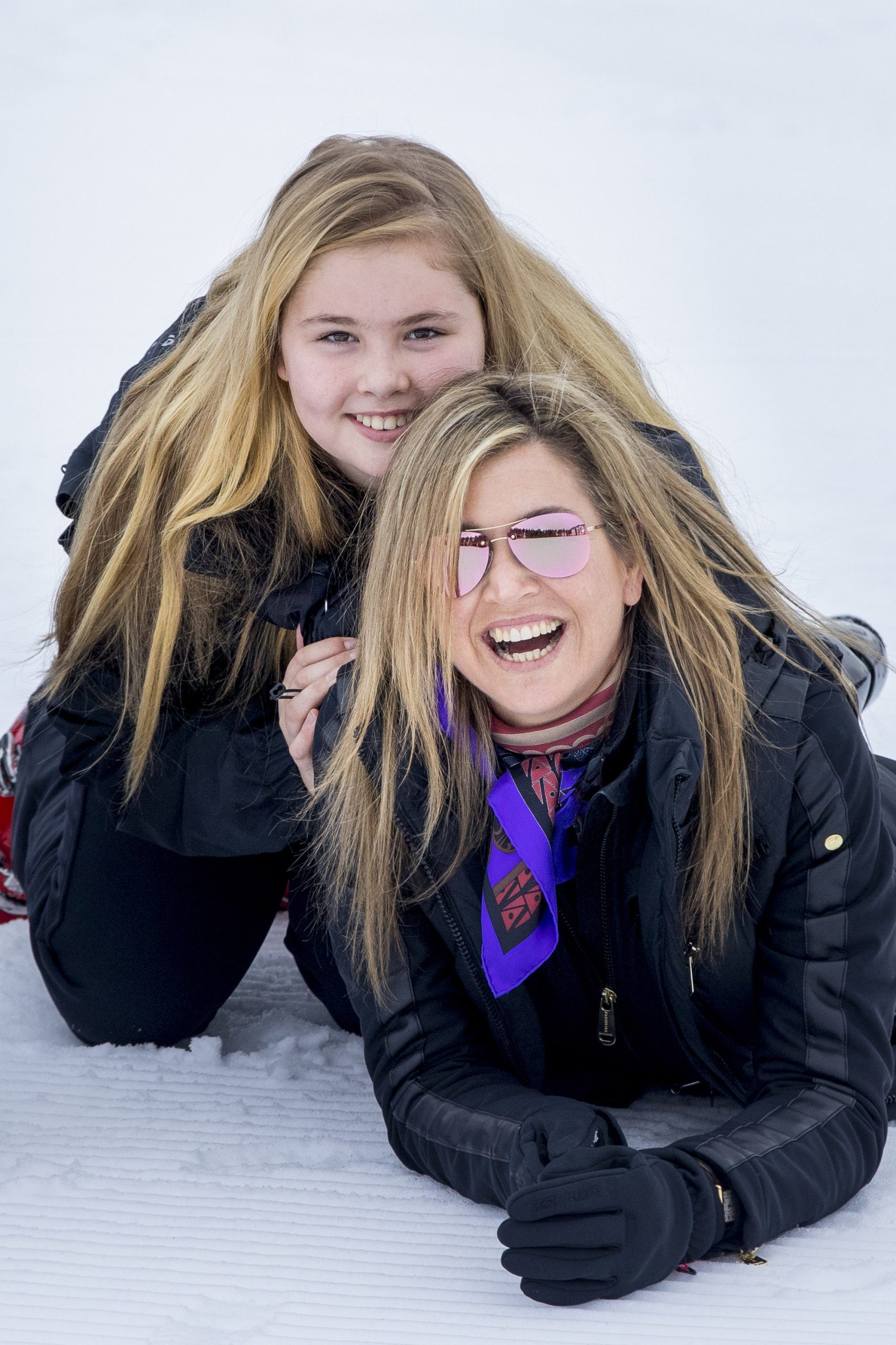 Lachend in de sneeuw met haar moeder tijdens de wintersportvakantie van de koninklijke familie in Lech, februari 2017.