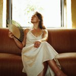 Vrouw gebruikt waaier om af te koelen van overgang