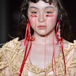 Model met rode strikjes op haar wangen