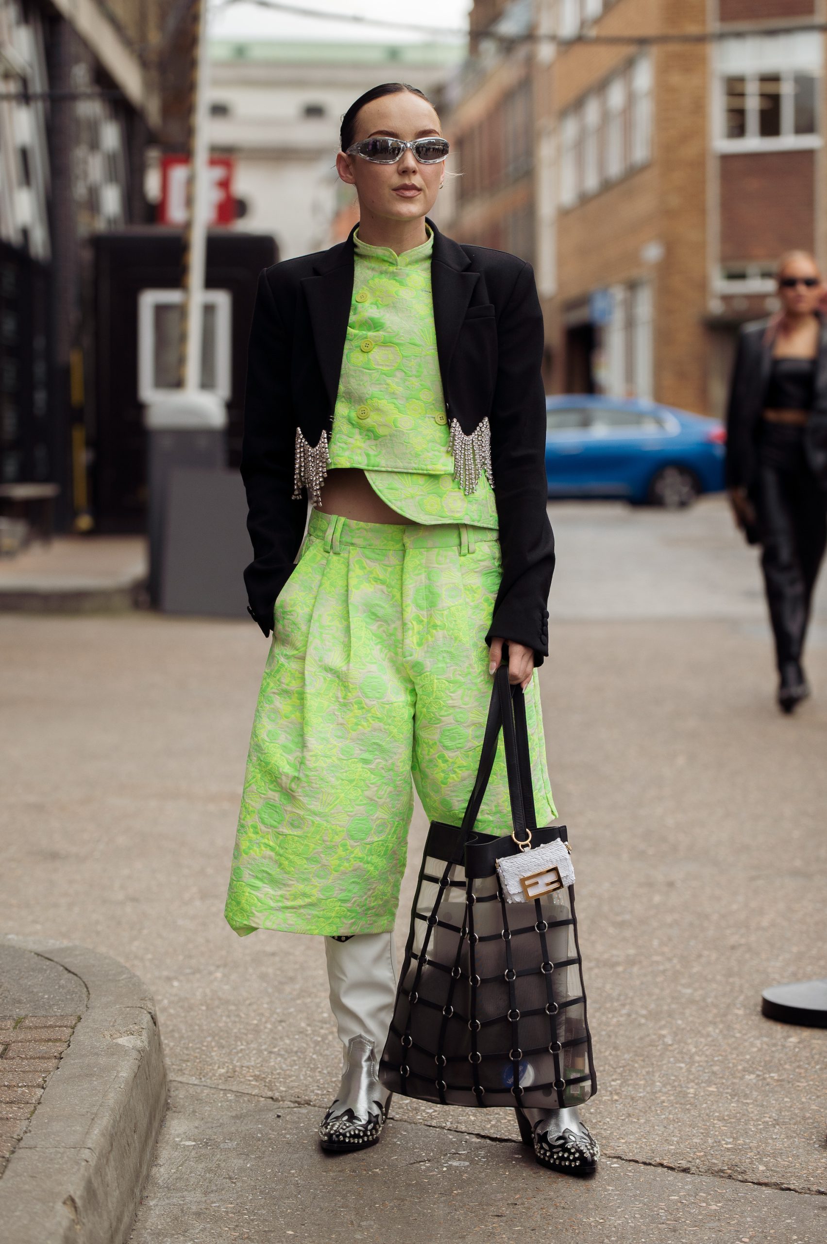 Een gast in het neongroen tijdens London Fashion Week