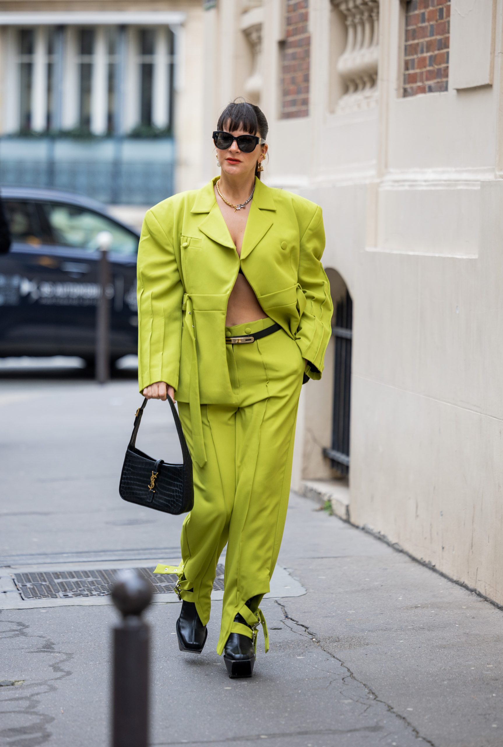 Een gast in het neongroen tijdens Paris Fashion Week
