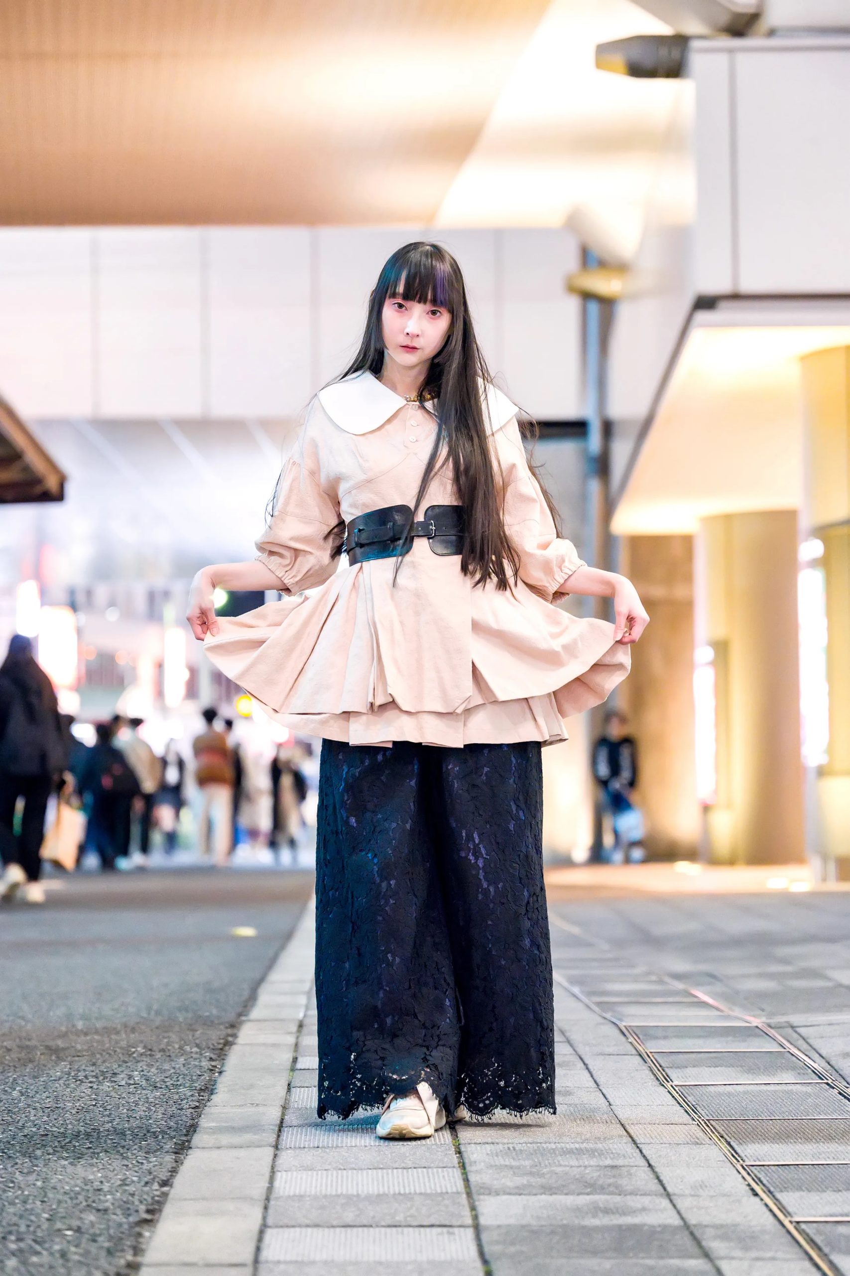 Vrouw in elegante jurk gedragen boven broek als streetstyle look tijdens Tokio Fashion Week