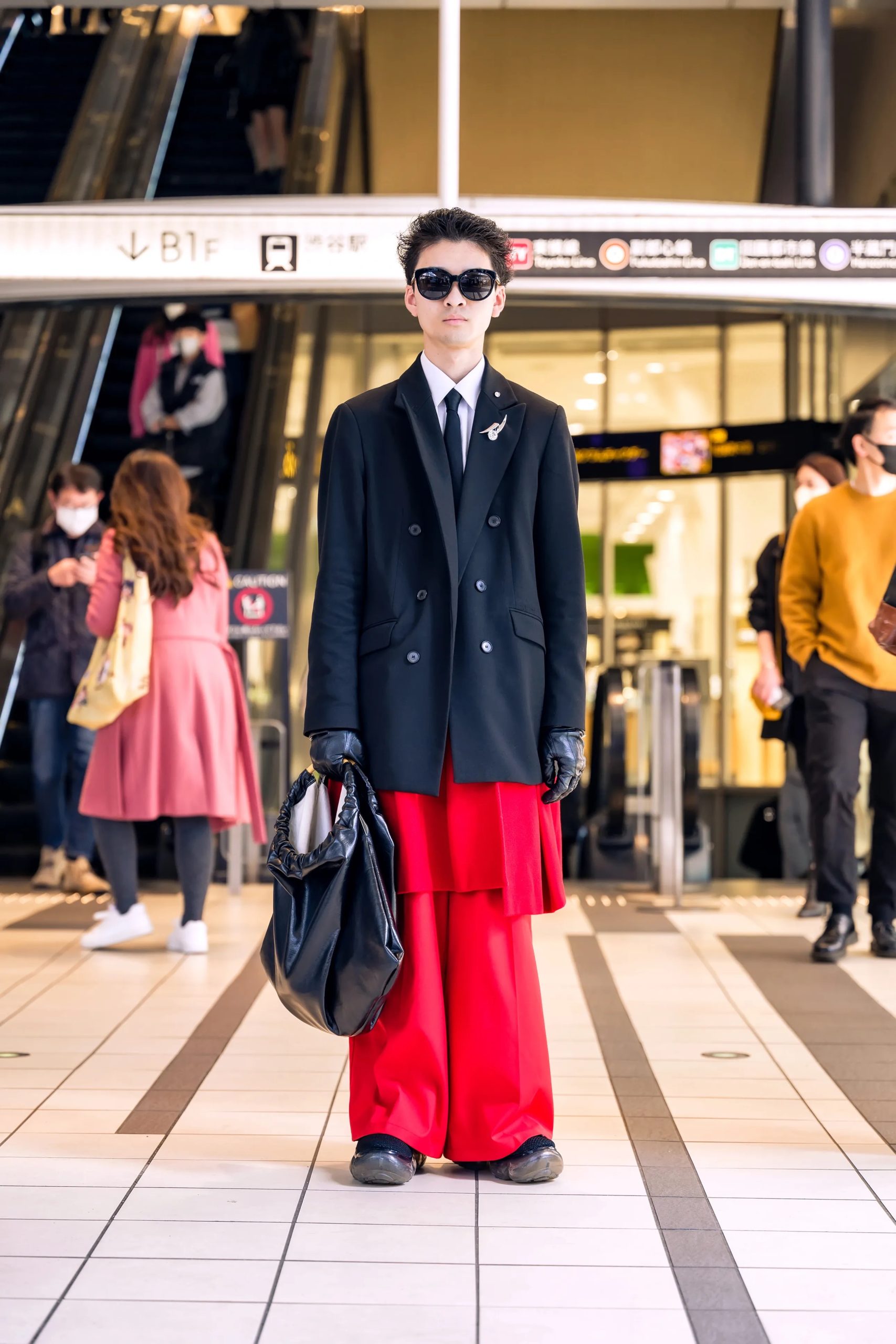 Man draagt pak met rode broek tijdens Tokio Fashion Week