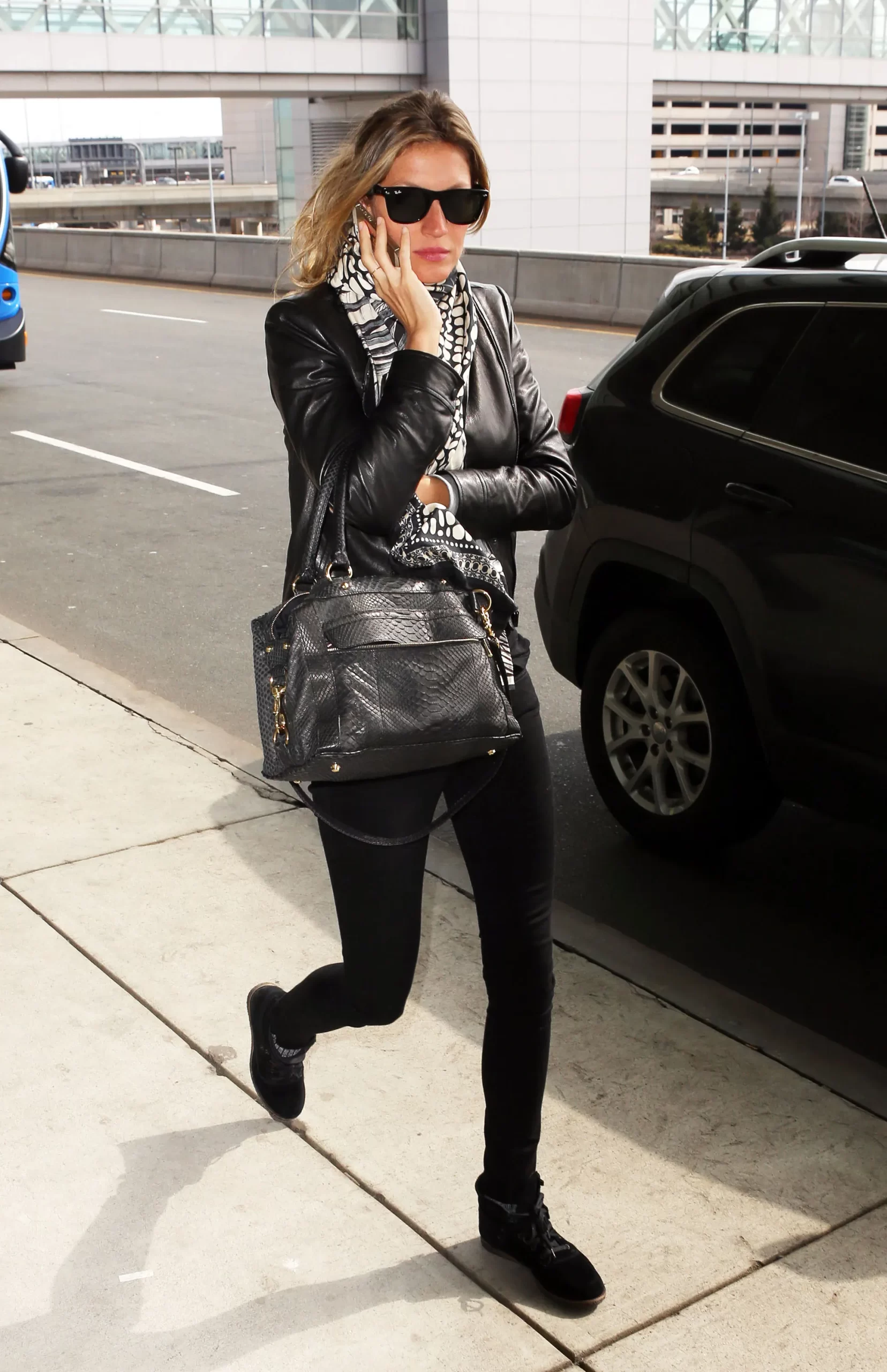 Gisele aan de telefoon met zwart paar skinny jeans