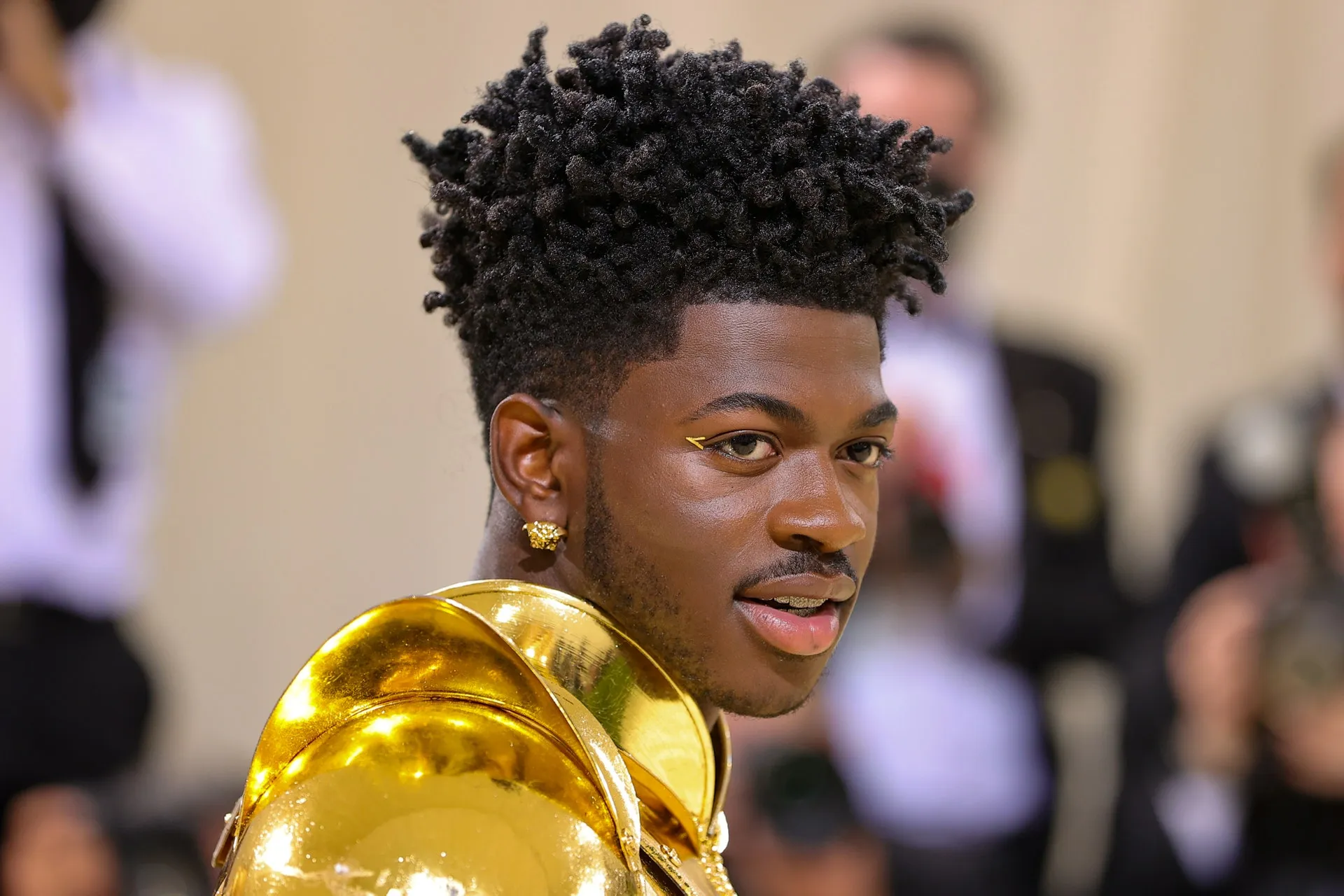 Lil Nas X in goud robotachtig pak en droeg gouden eyeliner als make-up look bij het Met Gala 2021