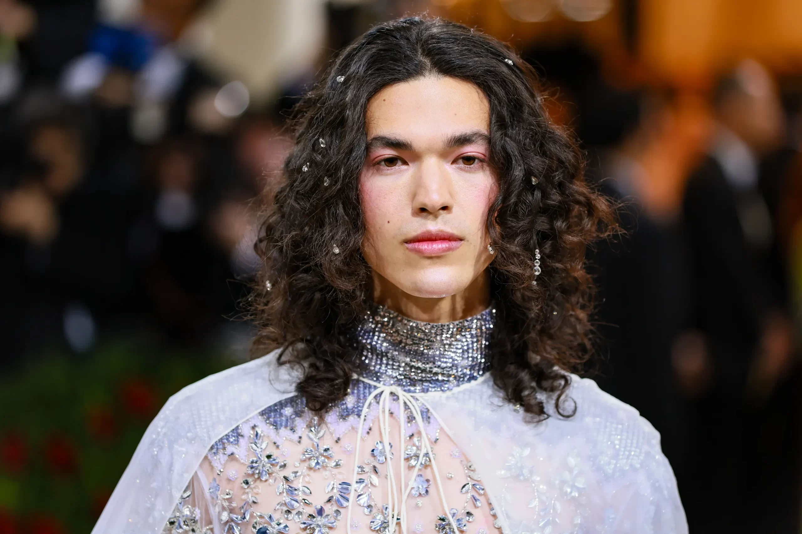 Conan Gray op het met gala van 2021 in een lila kleurige outfit met roze blush op zijn wangen