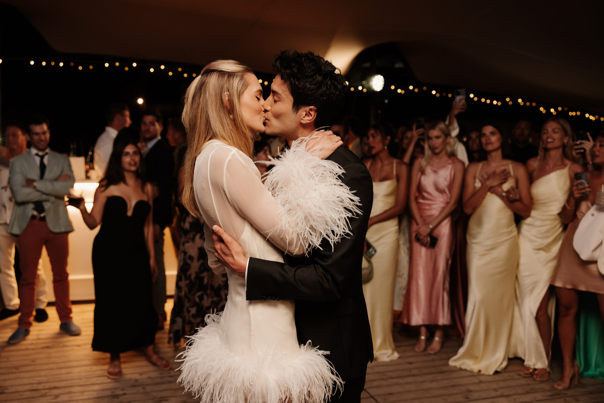 Sanne en Max kussen elkaar op het trouwfeest