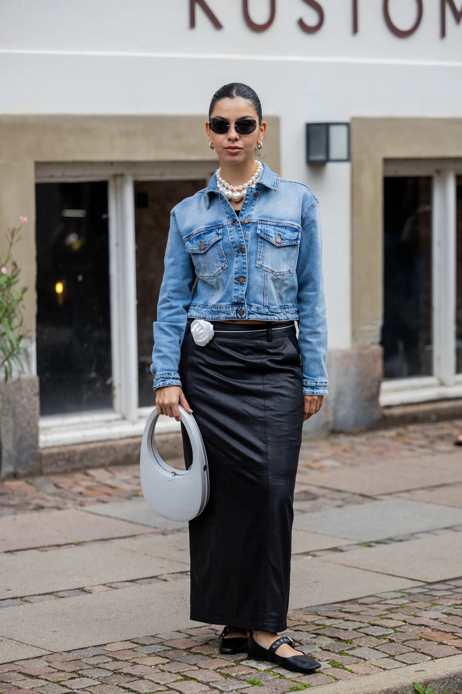 Een look bestaande uit een denim jas en een leren rok