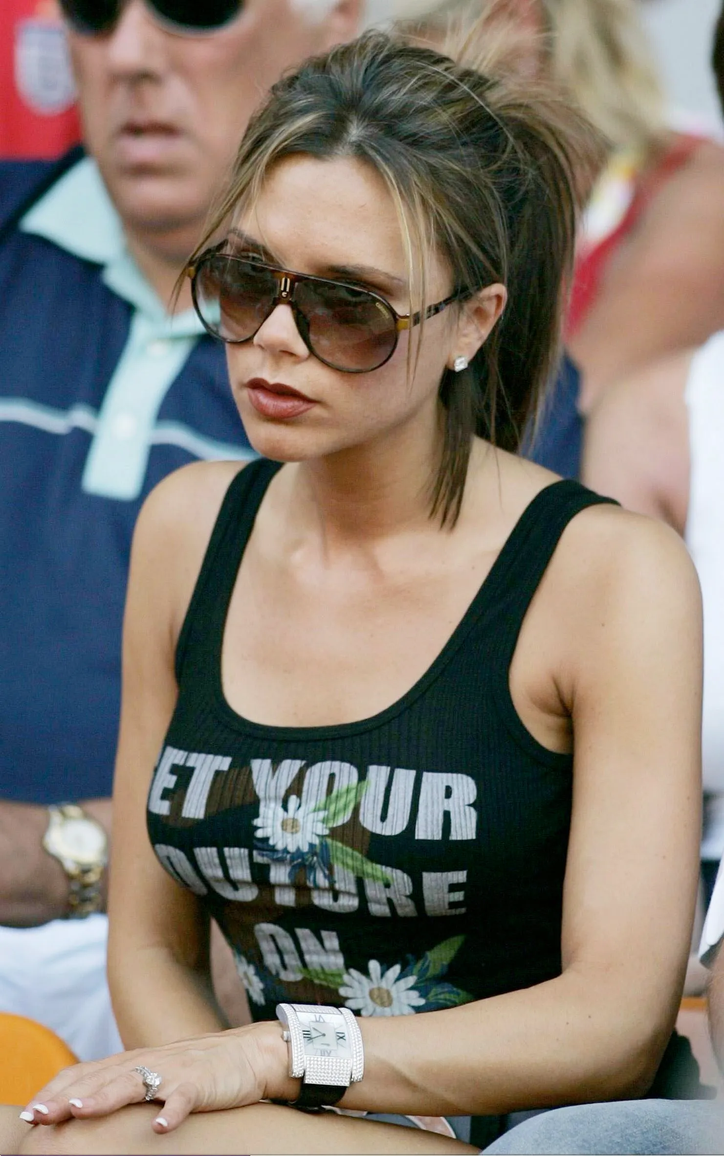 Victoria Beckham in een tanktop bij voetbalwedstrijd