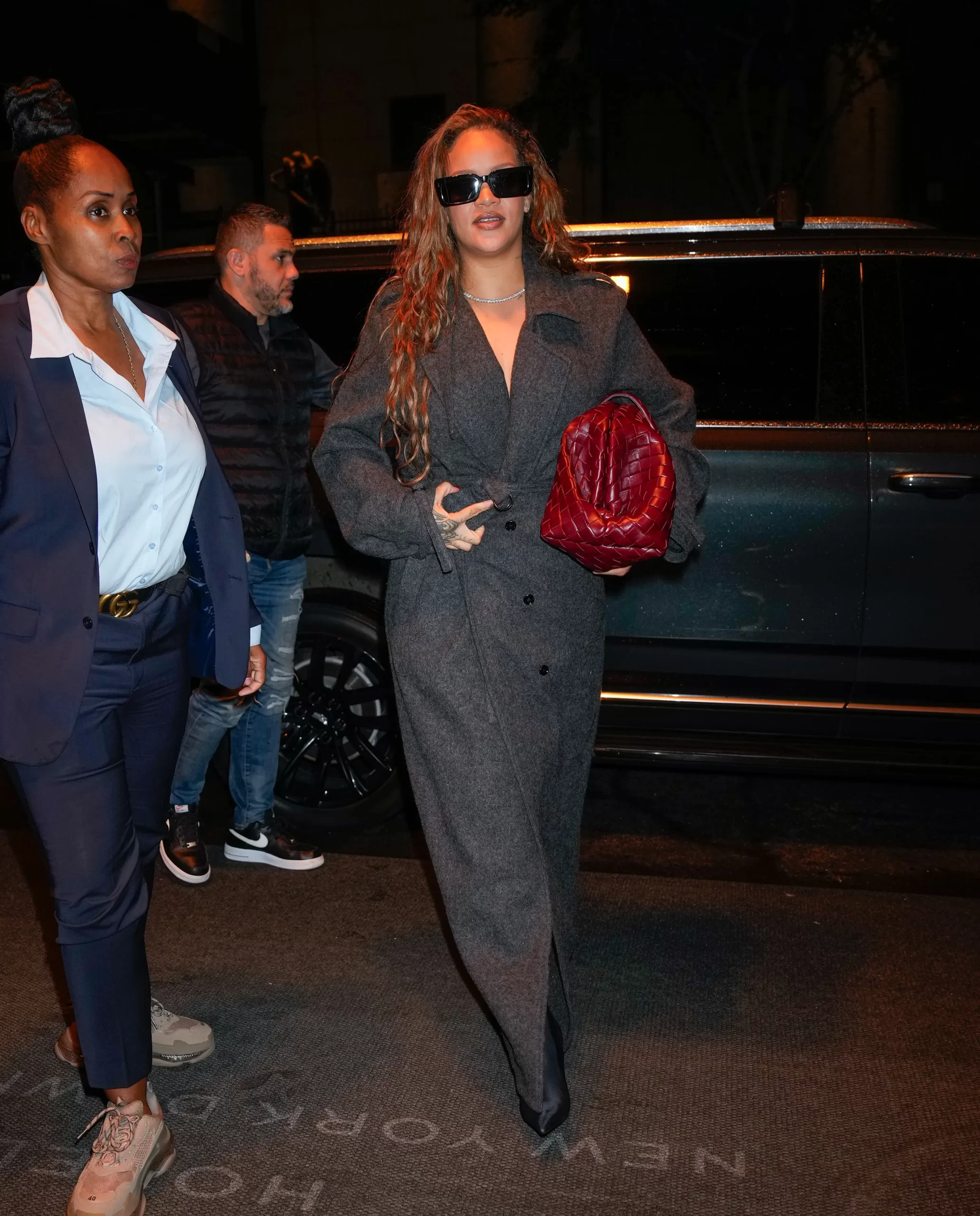 Riri in een lange grijze jas van Dries van Noten