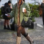 Een streetstyler met een koffie met havermelk