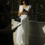 Een streetstyler met een telefoon in haar hand