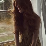 Model kijkt uit raam, beed uit Vogue maart 2022