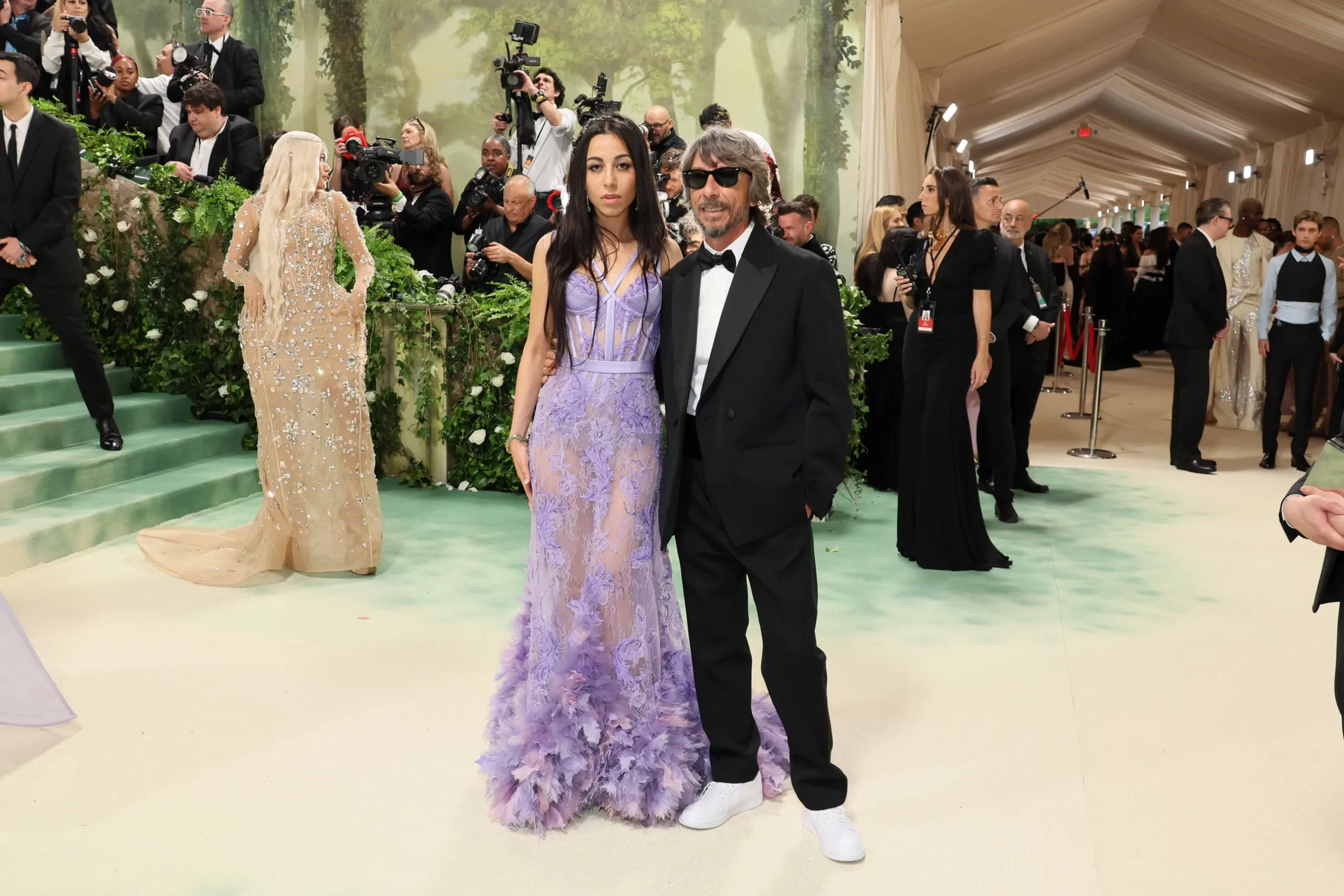 Benedetta Piccioli in een lila doorschijnende jurk met bloemen en Pierpaolo Piccioli in een zwart pak