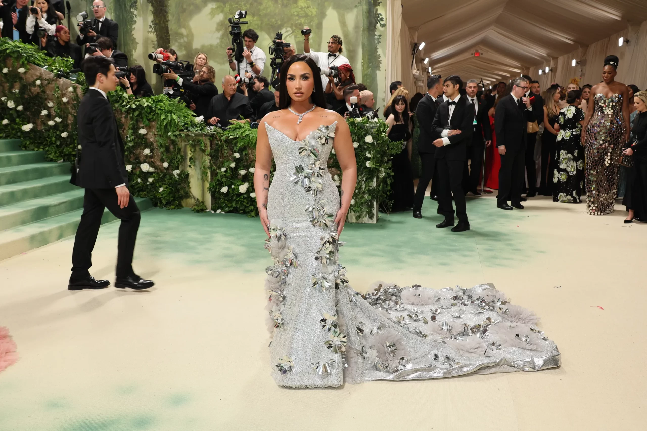 Demi Lovato in een zilveren jurk met bloemendetails