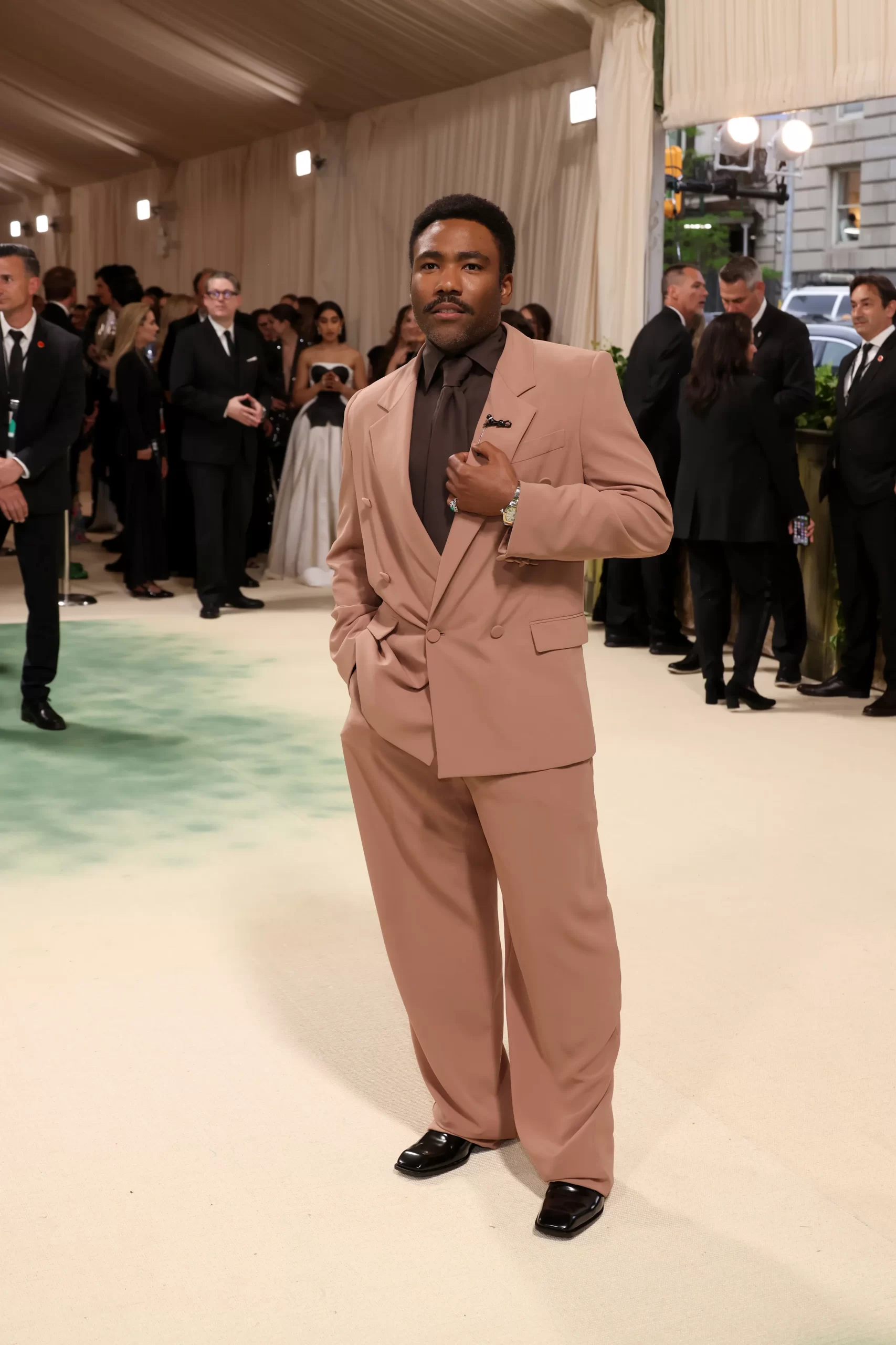 En Donald Glover in een warm zandkleurig pak
