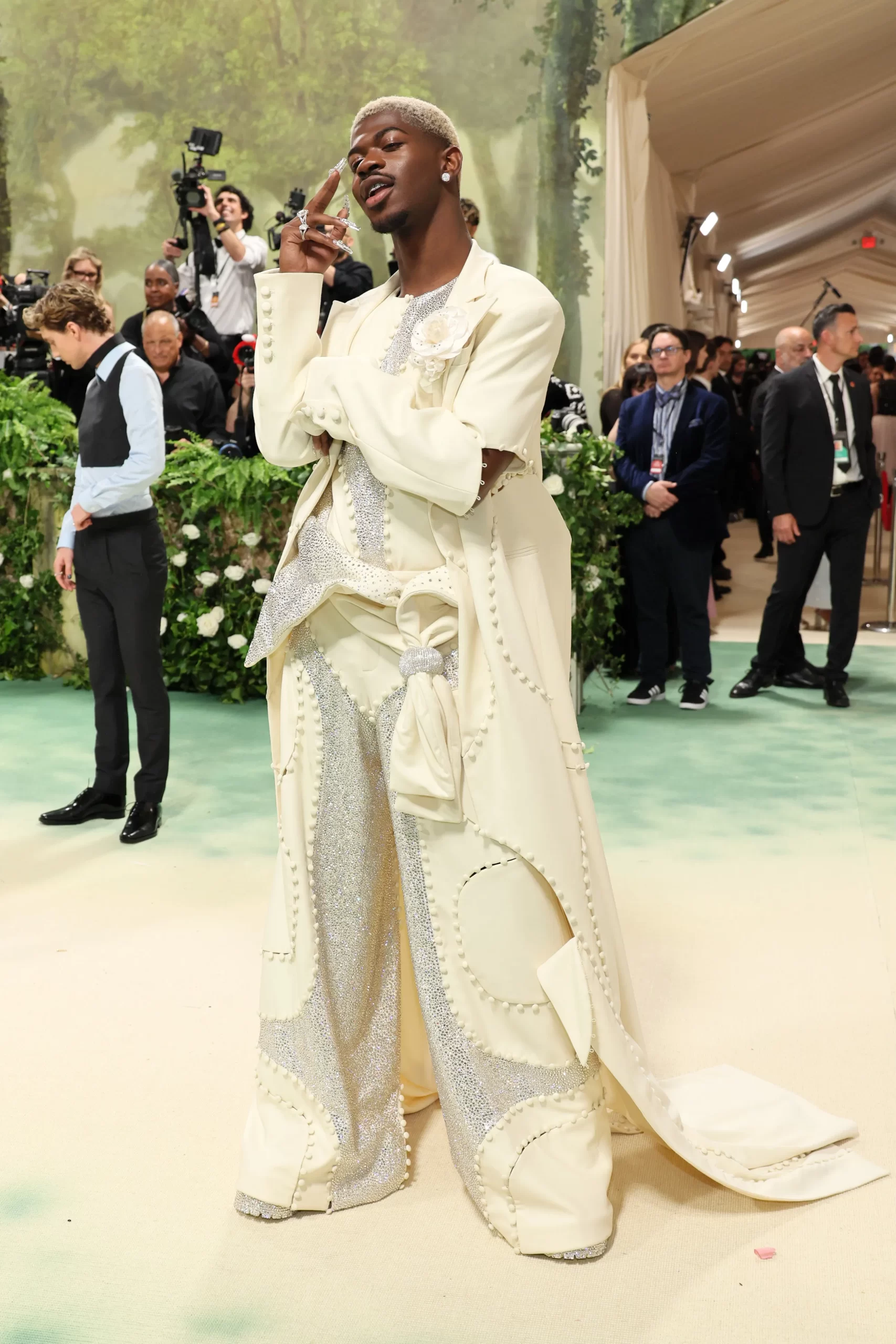 Lil Nas X draagt een witte look met lange cape tot de grond