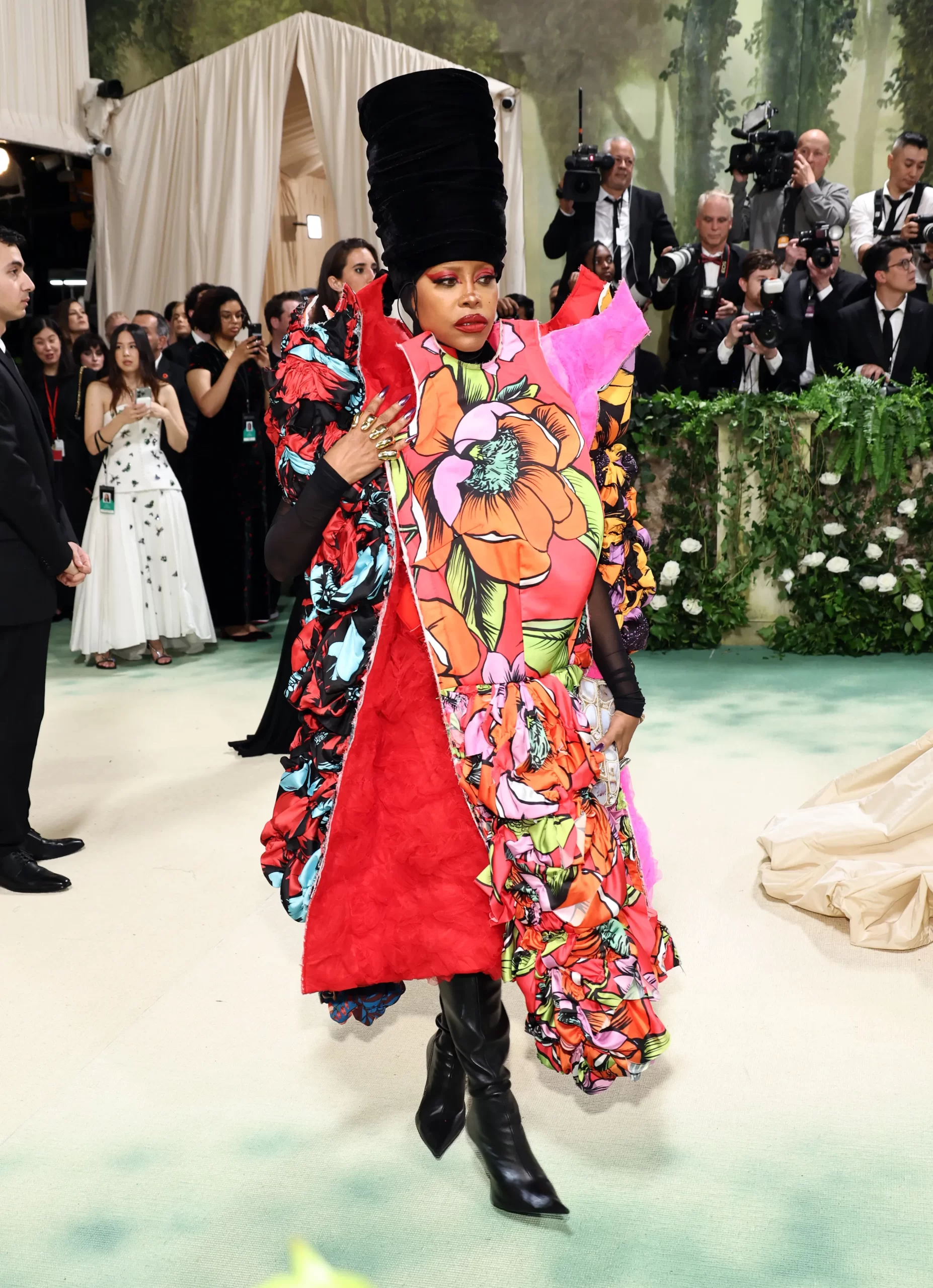 Erykah Badu in een jurk met rode bloemen
