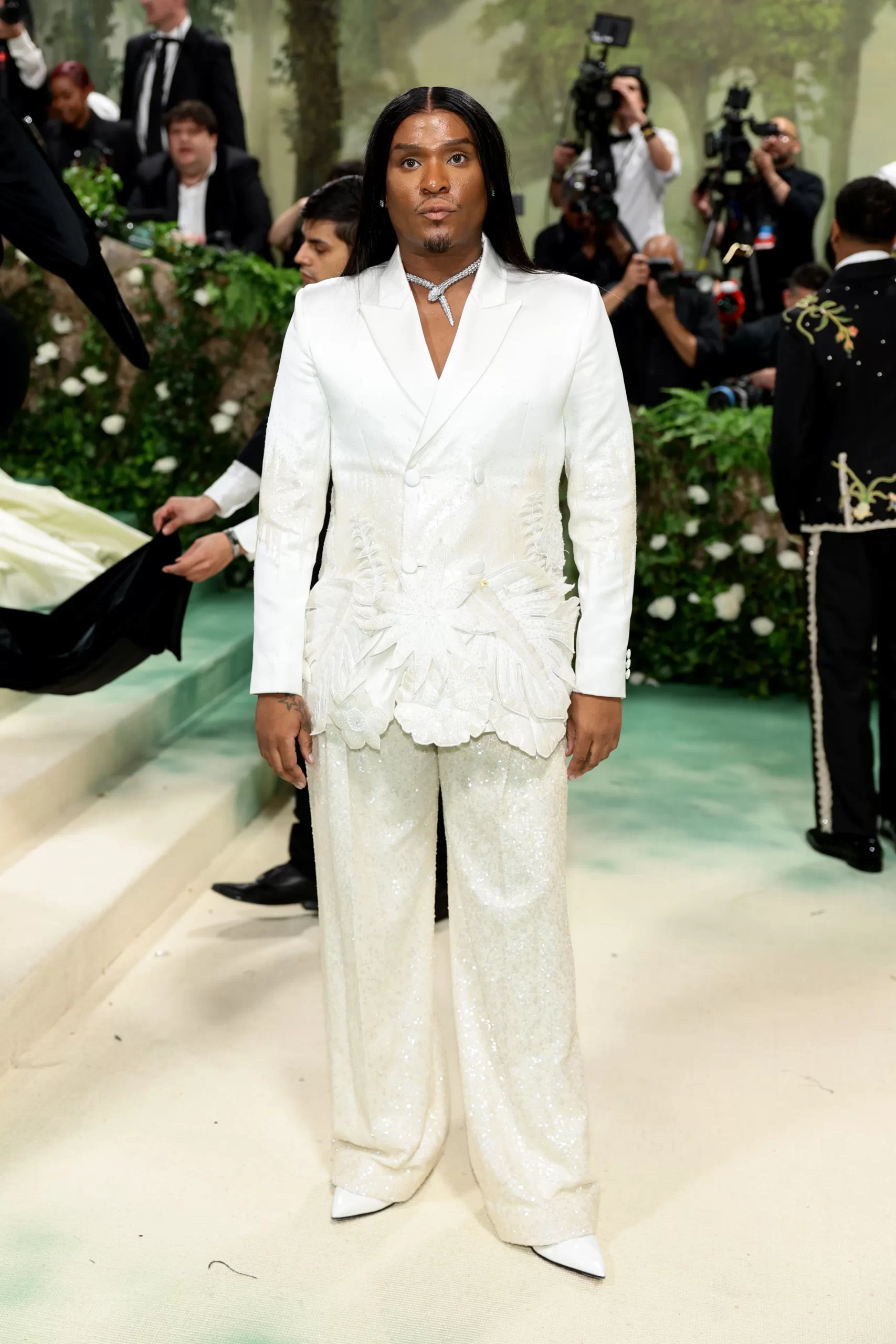 Law Roach in een wit pak met bloemendetails en paillettenbroek