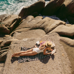 Vrouw leest een boek op het strand.