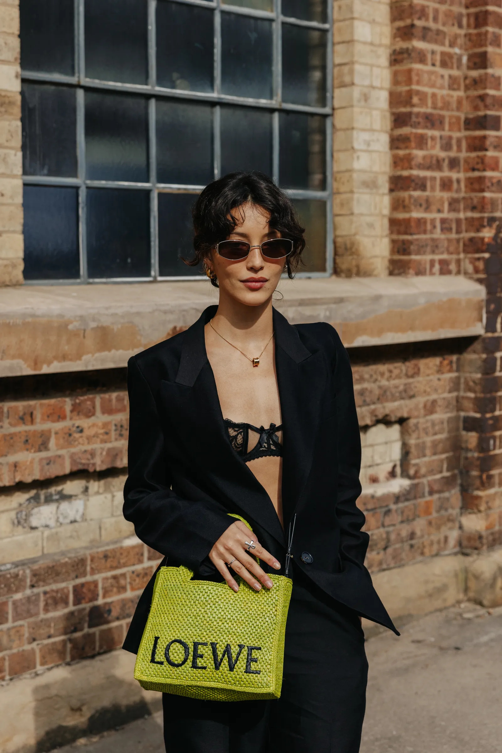 Streetsyle look met een groene Loewe-tas in brag green