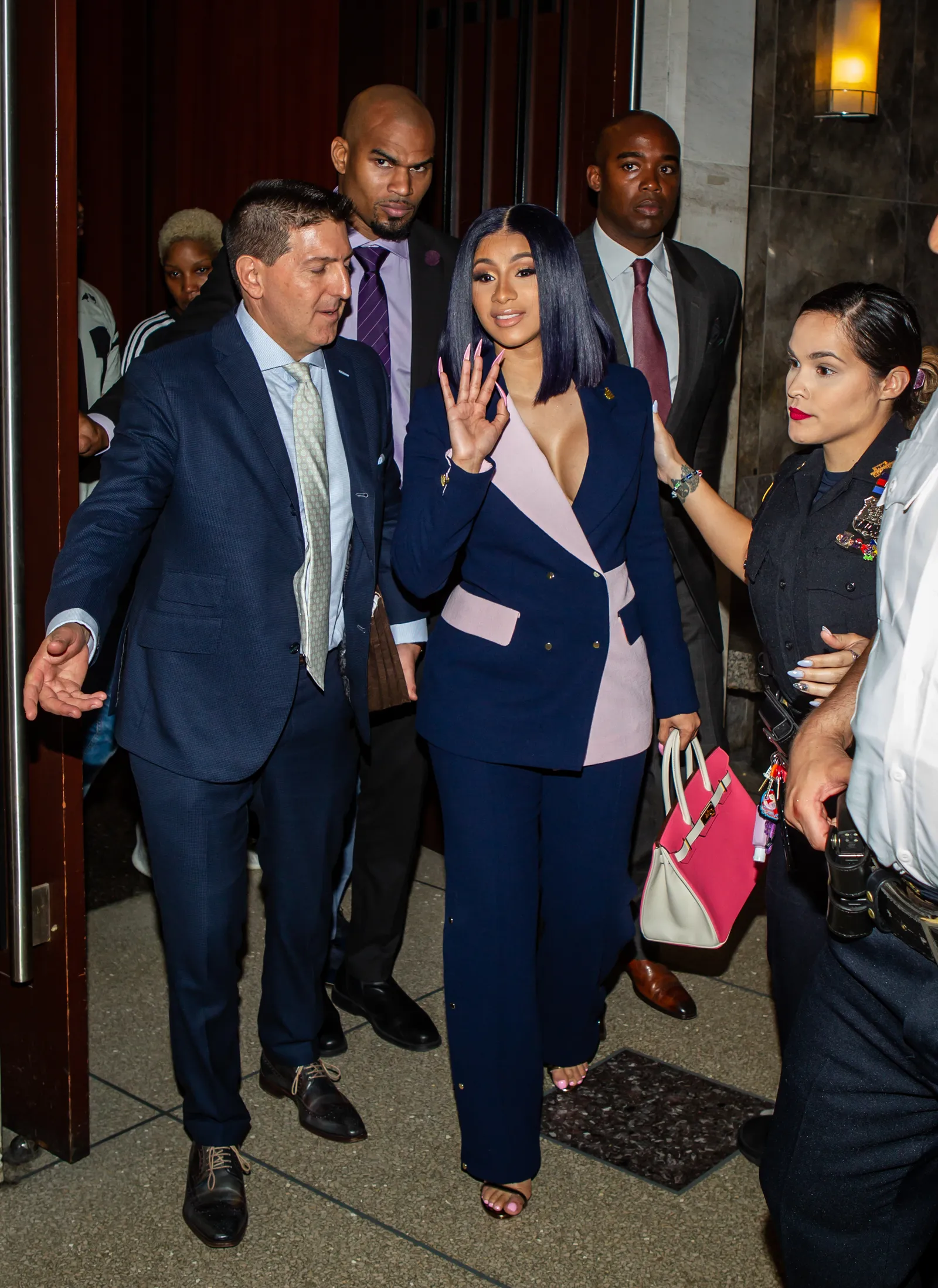 Cardi B in een blauw-roze pak voor de rechtbank