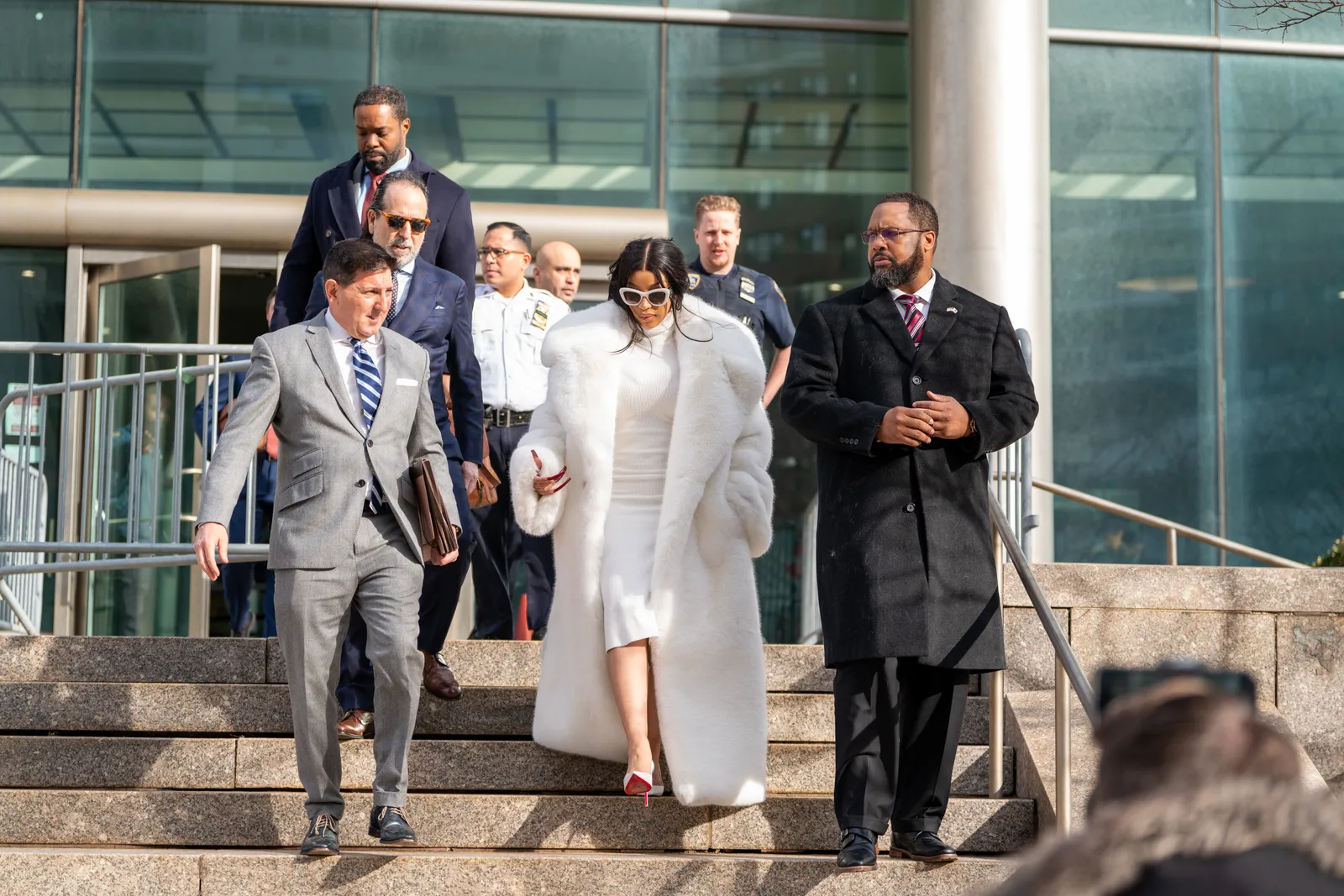 Cardi B in een witte jurk en manteljas bij de rechtbank