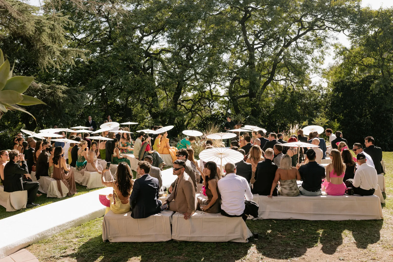 Gasten buiten op de banken bij Meeka Hossain en Jeffrey Kleins bruiloft