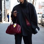 Een streetstyler draagt een bordeauxrode tas