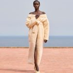 Model Anok Yai draagt een badjas op de catwalk van Jacquemus herfst/winter 2024