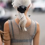 Vrouw met zijden scrunchie van Prada in haar haar