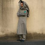 Een man staat tegen een muur