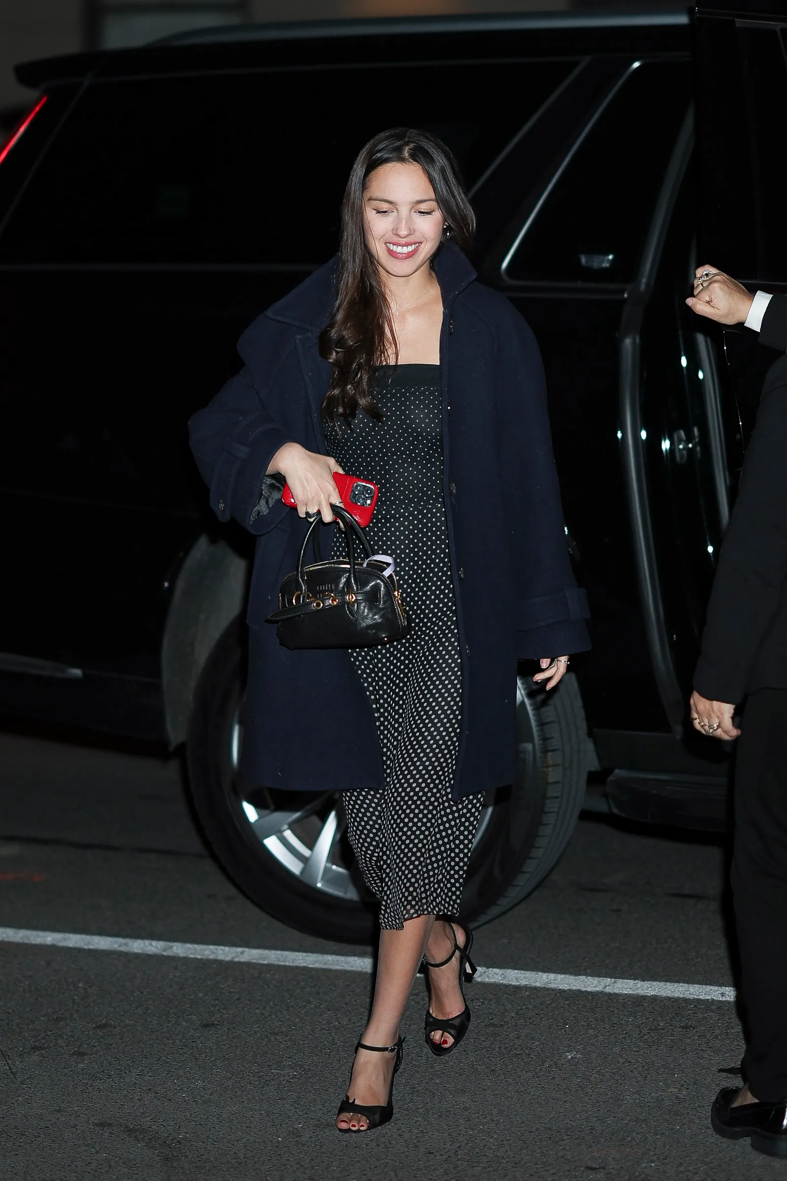 Olivia Rodrigo in polkadot jurk en lange jas