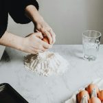 Vrouw breekt ei tijdens het bakken