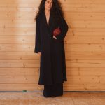 Gisele Azad voor haar houten woning.