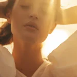 Een vrouw in de zon, ter illustratie van een artikel over je stresslevel verlagen