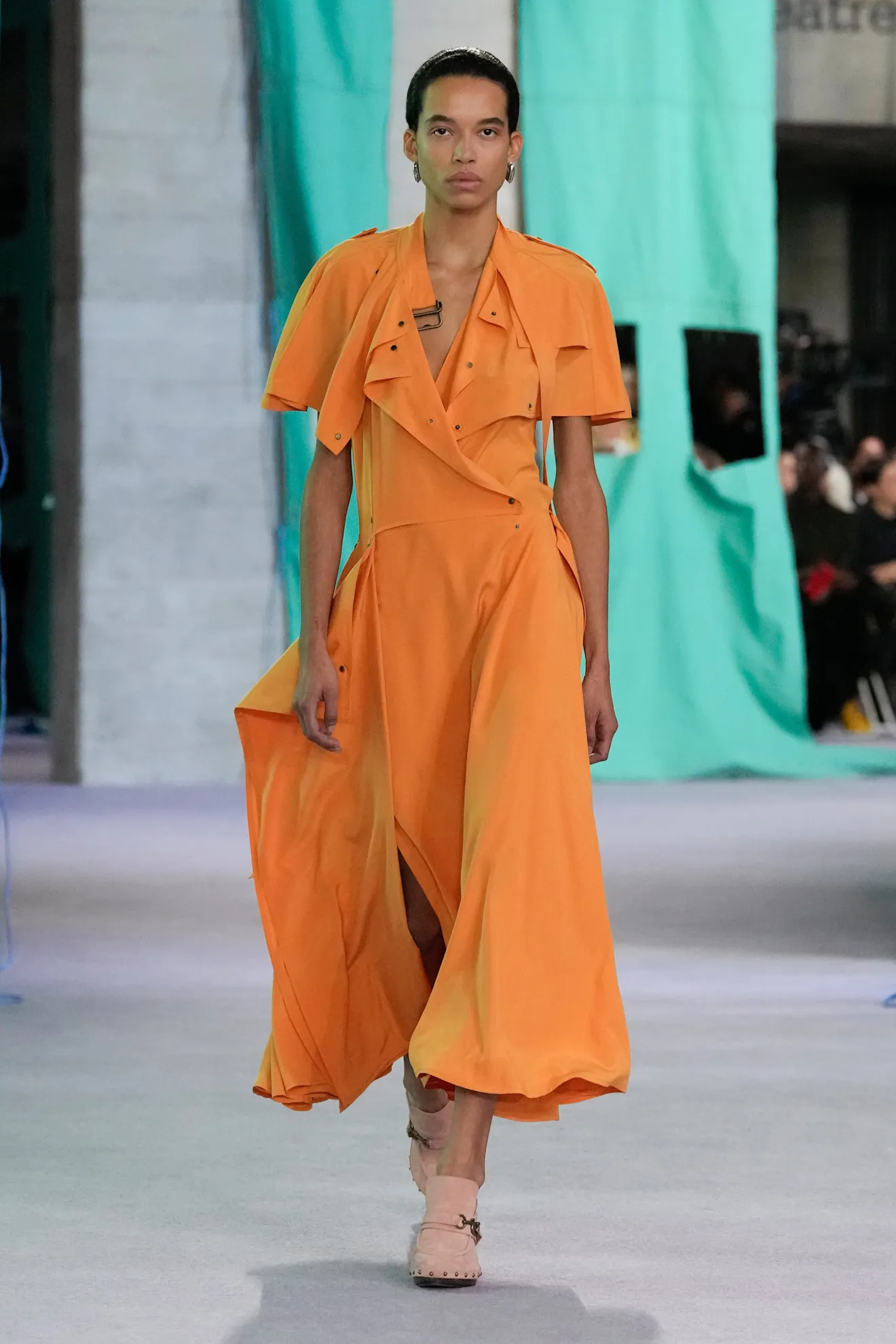 Model op de catwalk van Burberry in oranje outfit