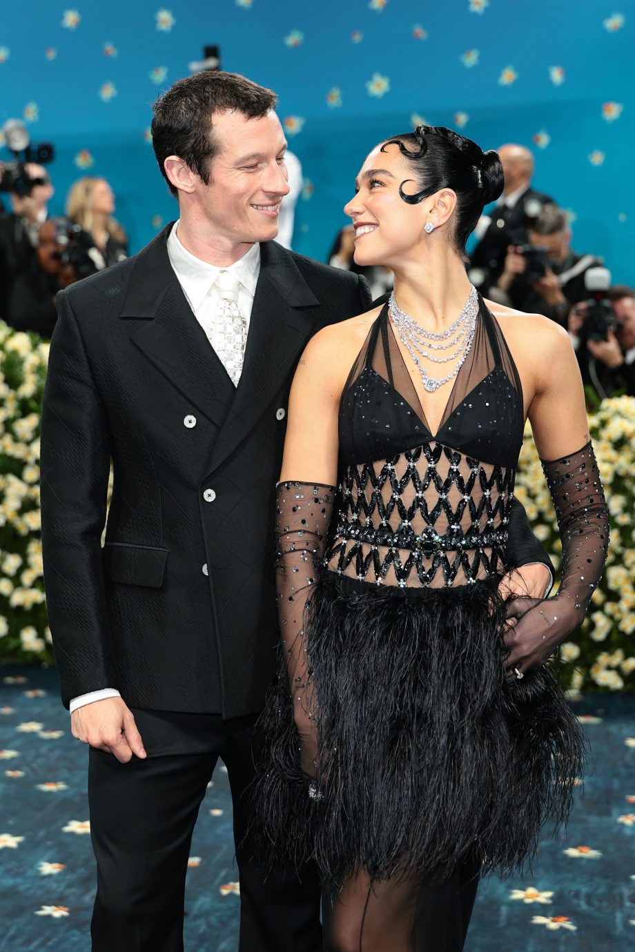 dua-lipas-chanel-look-voor-het-met-gala-2025-is-versierd-met-veren-kristallen-en-callum-turner-345129