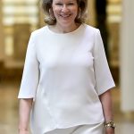 Koningin Mathilde in een witte look met gouden sieraden