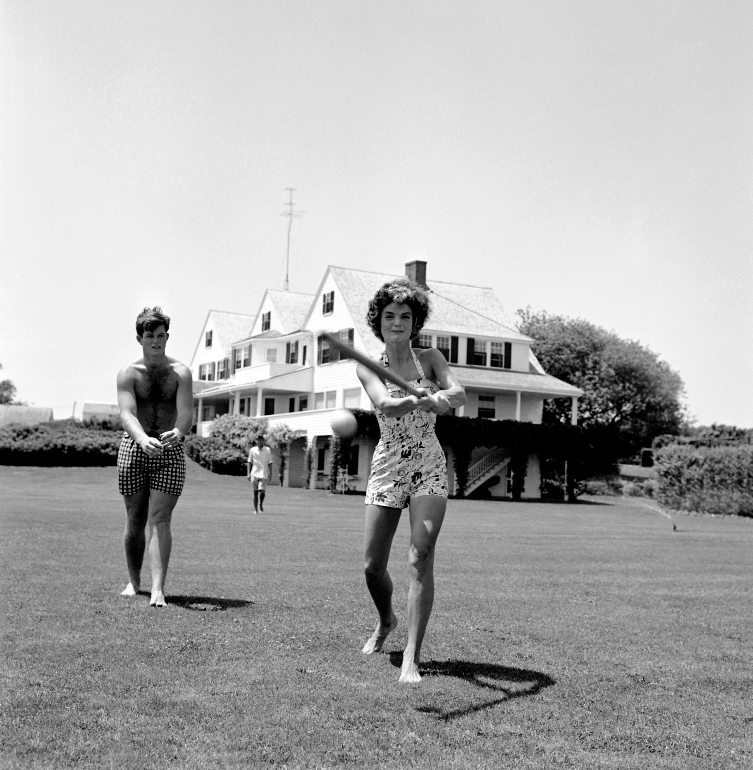 Jackie, John F. Kennedy en Edward 'Ted' Kennedy spelen honkbal op het gazon in Hyannis Port.