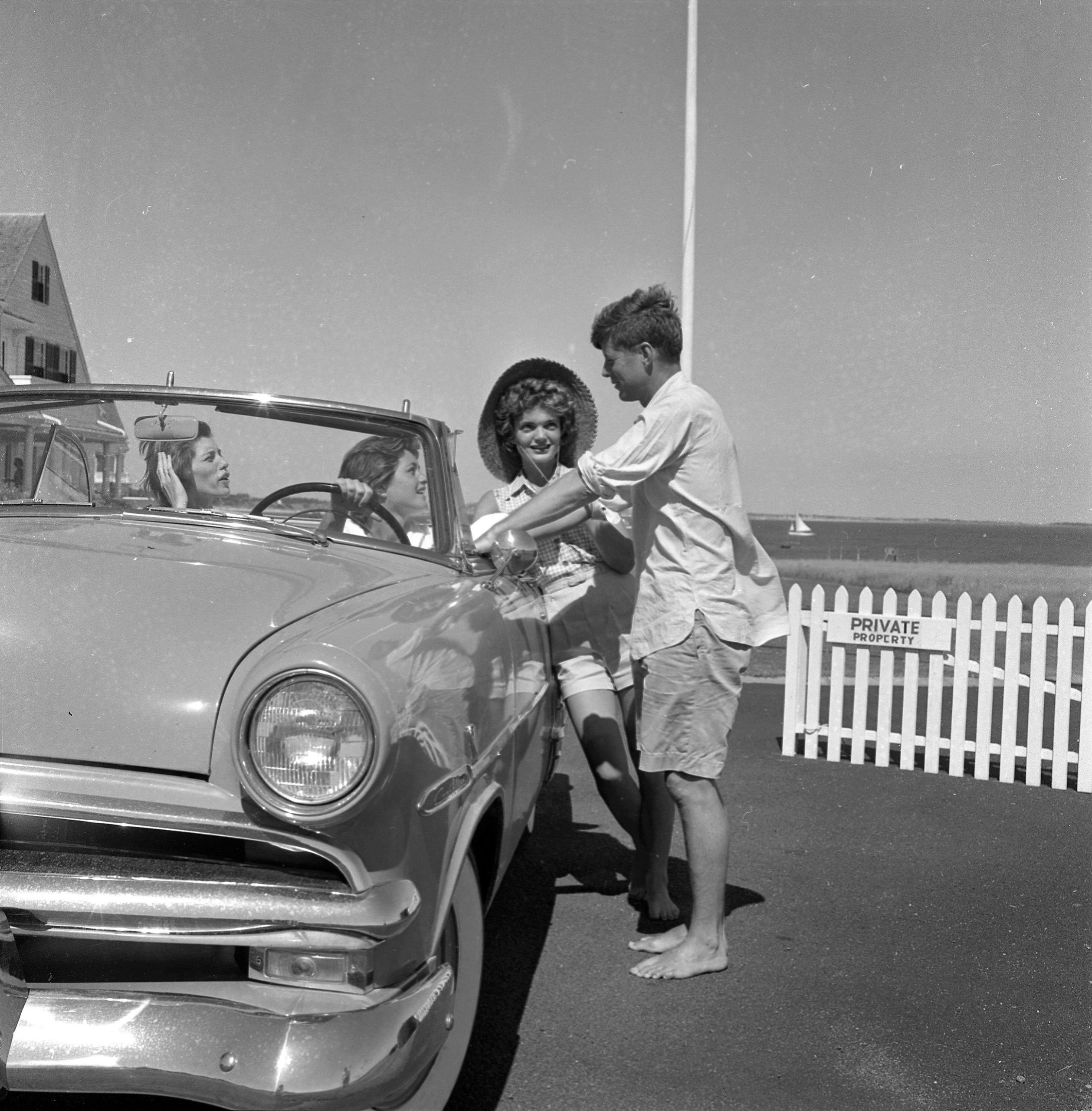 John F. Kennedy en Jackie Kennedy praten met Eunice Kennedy en Patricia Kennedy.