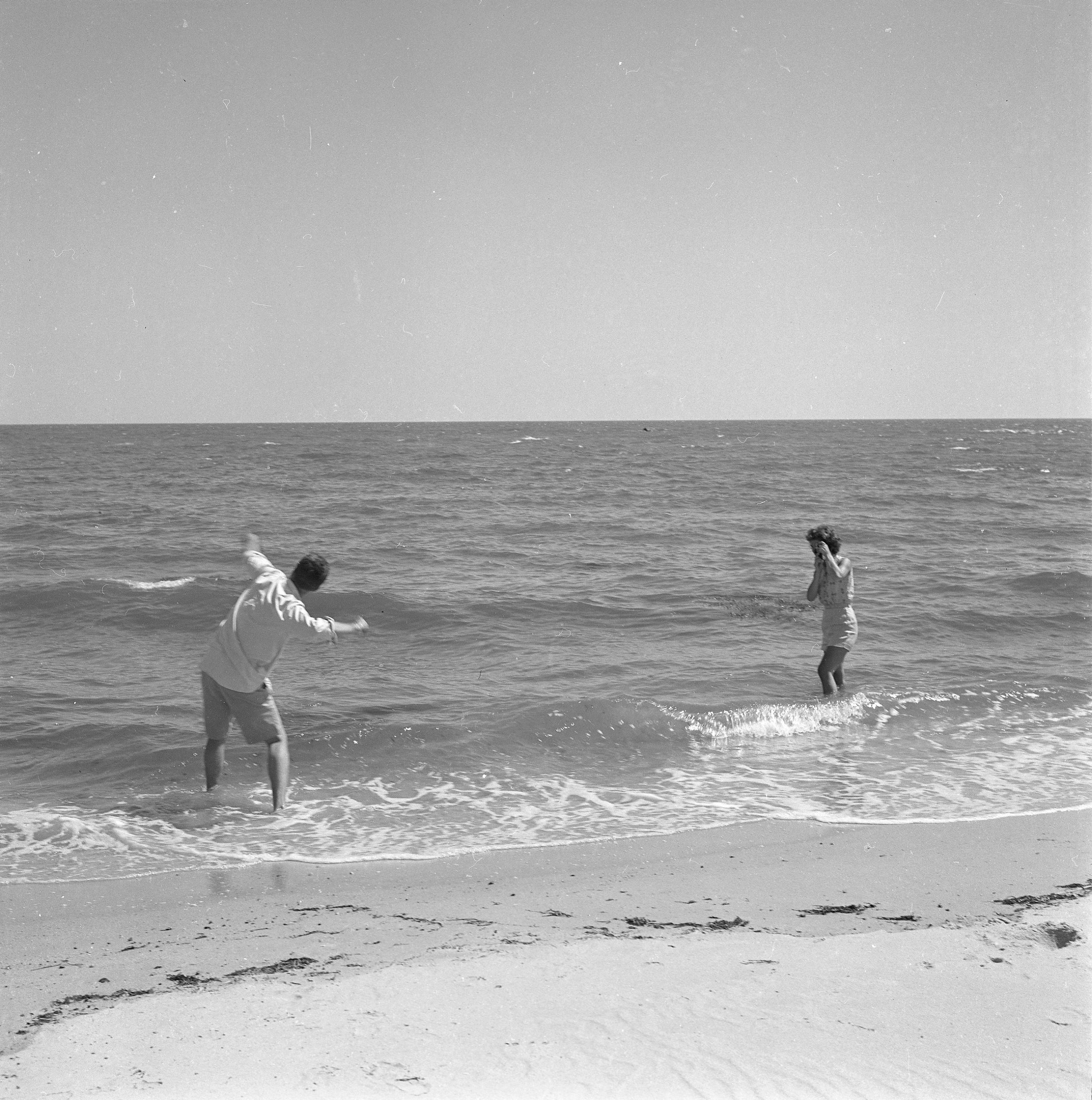 John en Jackie spelen in het water van de Atlantische Oceaan.