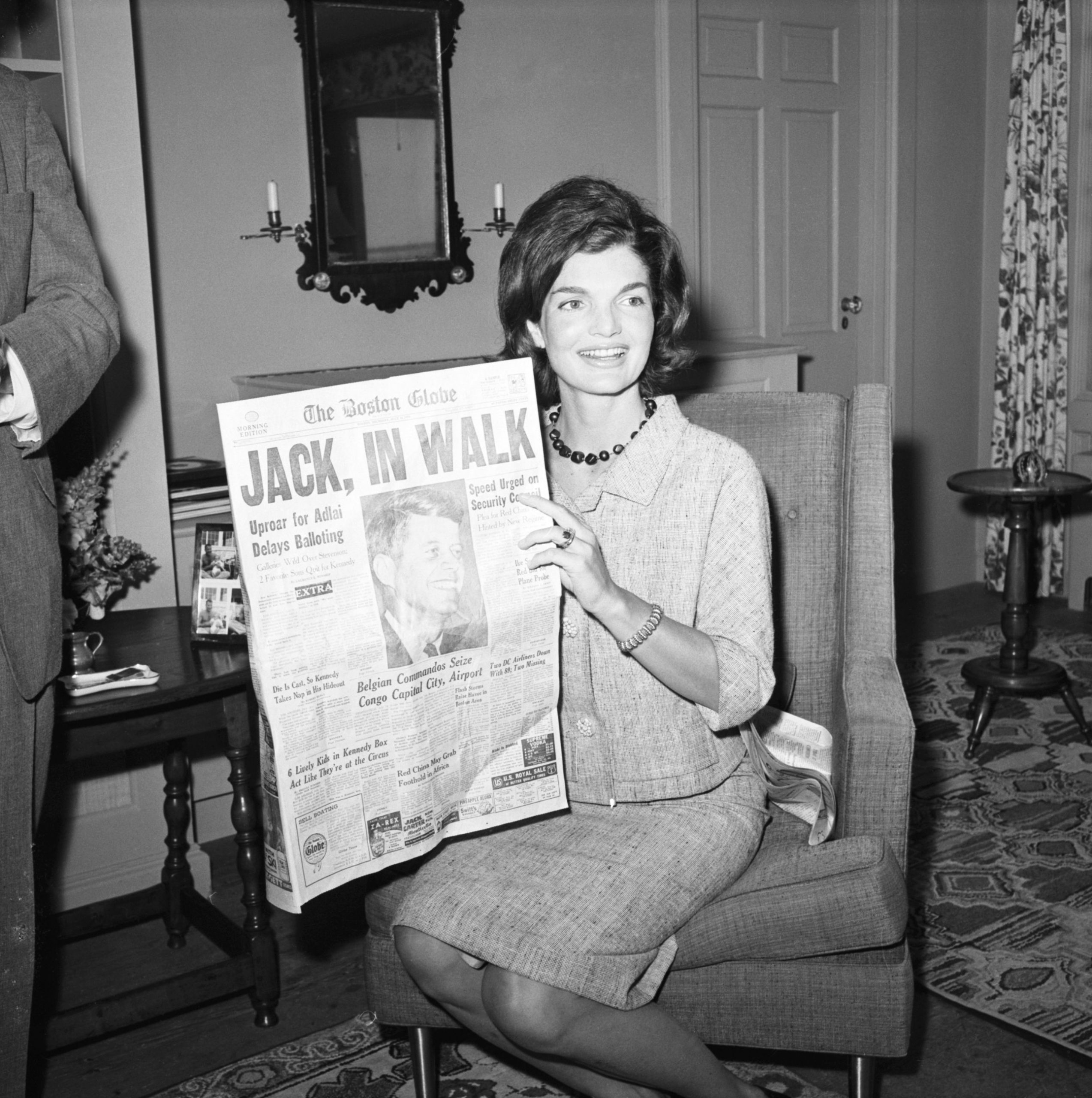 Jackie Kennedy straalt terwijl ze in Hyannis Port de krant leest over haar man, senator John F. Kennedy, die bij de eerste stemronde de presidentsnominatie van de Democratische Partij heeft gewonnen.