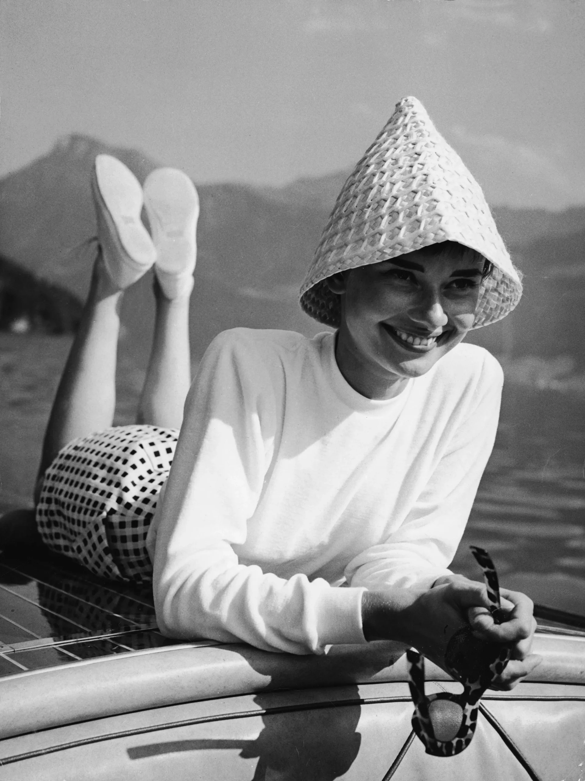 Audrey Hepburn ligt op de achterkant van een motorboot op een meer in Zwitserland, begin jaren vijftig.