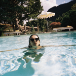 Een model zwemt in een zwembad in een zonnige omgeving