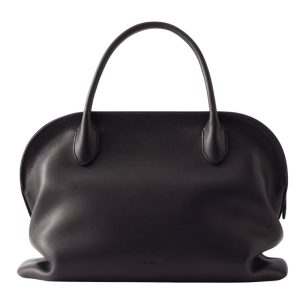 Tas van The Row voor bij een vliegtuigoutfit