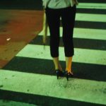 vrouw loopt over zebrapad in de nacht