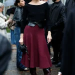 Milla Jovovich met bordeauxrode laarzen tijdens Paris Fashion Week