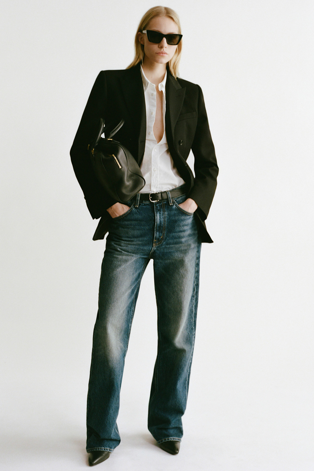 Vrouw draagt jeans met witte blouse.